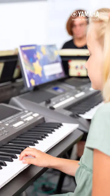 Dítě při hře na keyboard v hudební lekci