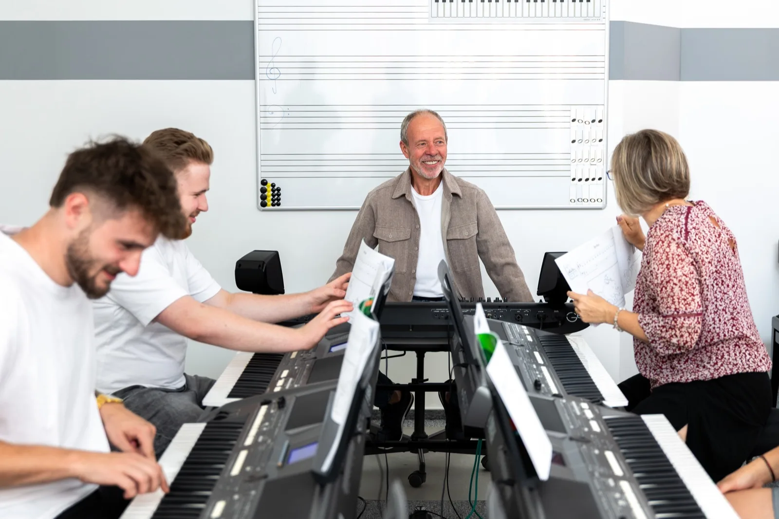 Dospělí hudebníci hrají společně na keyboardy v programu Fun Key
